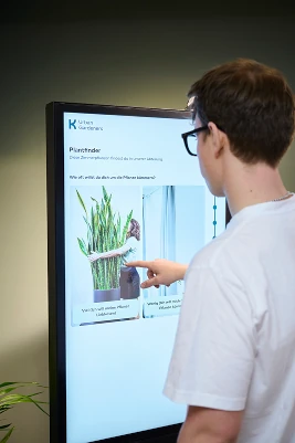 Bild von Valentin Kiefl an einem Touchdisplay der den Plantfinder demonstriert